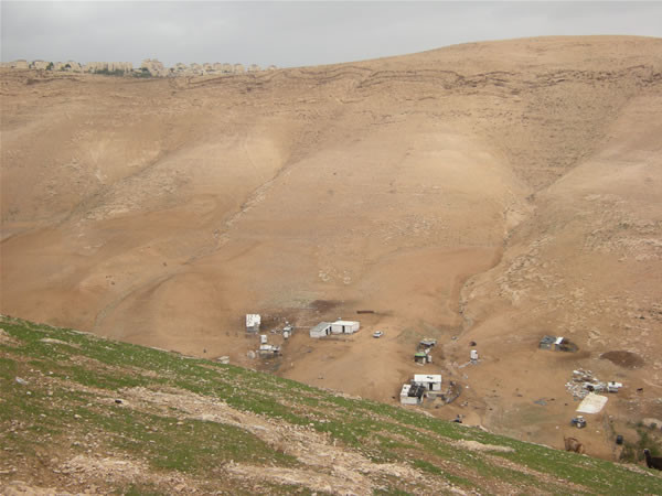 Sul ciglio di una delle colline sovrastanti s'affaccia (in alto a sin. nella foto) l'insediamento israeliano di Ma'ale Adumim.